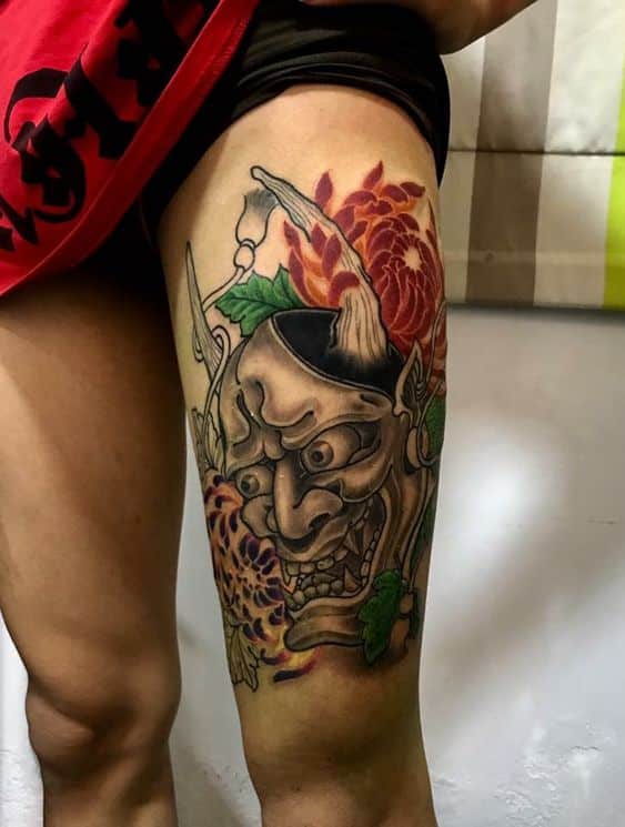 tattoo-hinh-xam-mat-quy-den-trang-va-hoa-mau-don-o-bap-dui tattoo hình xăm mặt quỷ đen trắng và hoa mẫu đơn ở bắp đùi