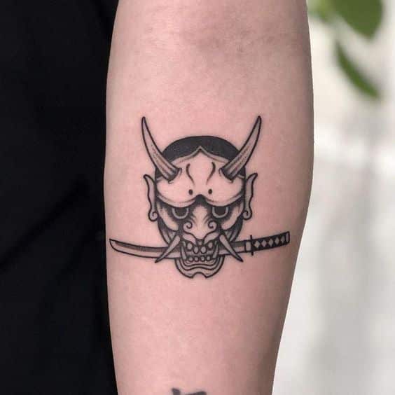 tattoo-mat-quy-mini-ngam-kiem-tren-canh-tay tattoo mặt quỷ mini đen trắng trên cánh tay